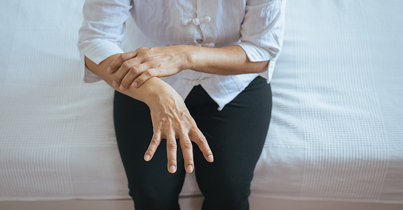 Mano de una persona mayor con temblor, síntoma característico del Parkinson.